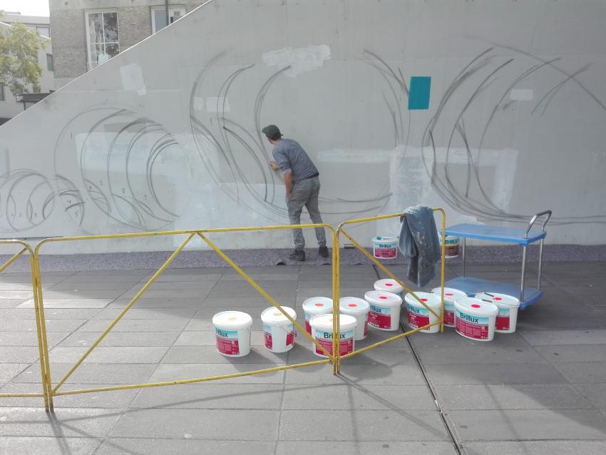 kunstenaar bezig met 3D graffiti kunstwerk bij ingang fietsenkelder 18 Septemberplein