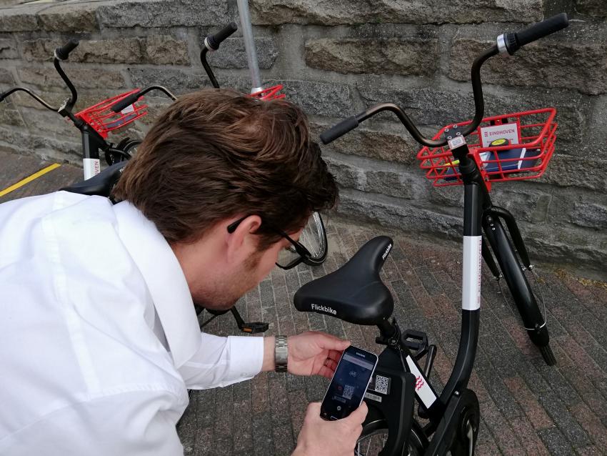 Inwoner van Eindhoven activeert via de app Flickbike een deelfiets