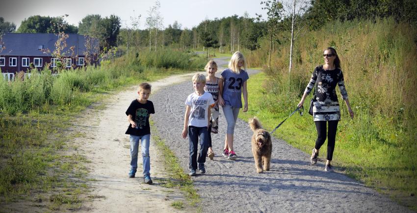 Vrouw en kinderen wandelen met hond