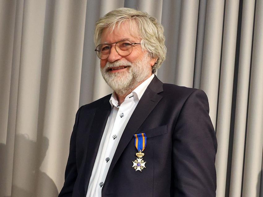 De heer Harm Rutten toont zijn koninklijke onderscheiding met een glimlach