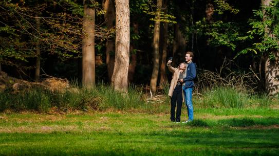 Een koppel maakt een selfie tussen het groen, klik voor een vergroting