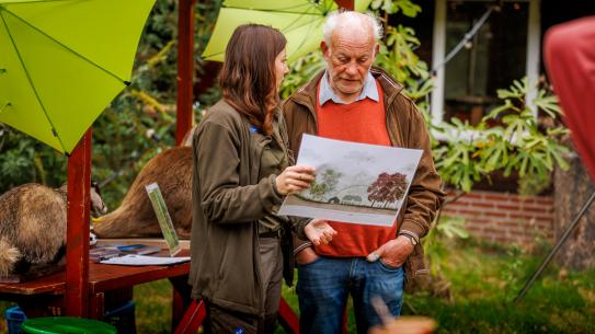 Bezoekers bekijken kaarten met sfeerimpressies, klik voor een vergroting