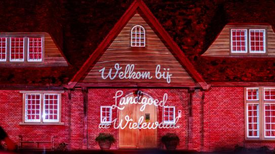 Landhuis De Wielewaal wordt verlicht met projecties tijdens de openingsshow, klik voor een vergroting