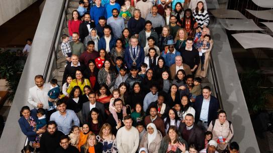 groepsfoto van de Naturalisatiebijeenkomst op de trap in het Stadhuis, klik voor een vergroting