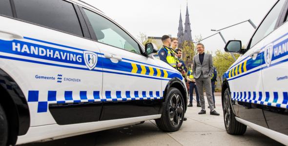 Handhavers praten met burgemeester Dijsselbloem naast hun nieuwe dienstauto's