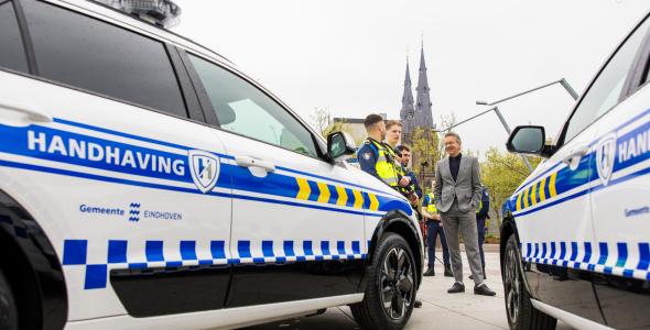 Handhavers praten met burgemeester Dijsselbloem naast hun nieuwe dienstauto's