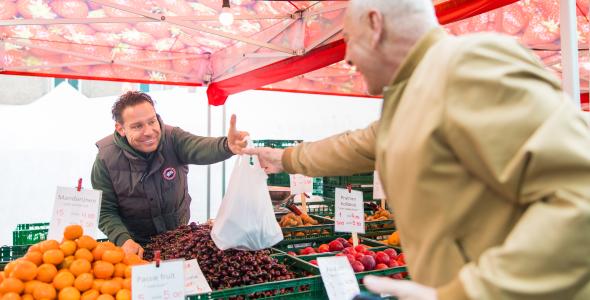 Op deze afbeelding staan twee personen op de weekmarkt.