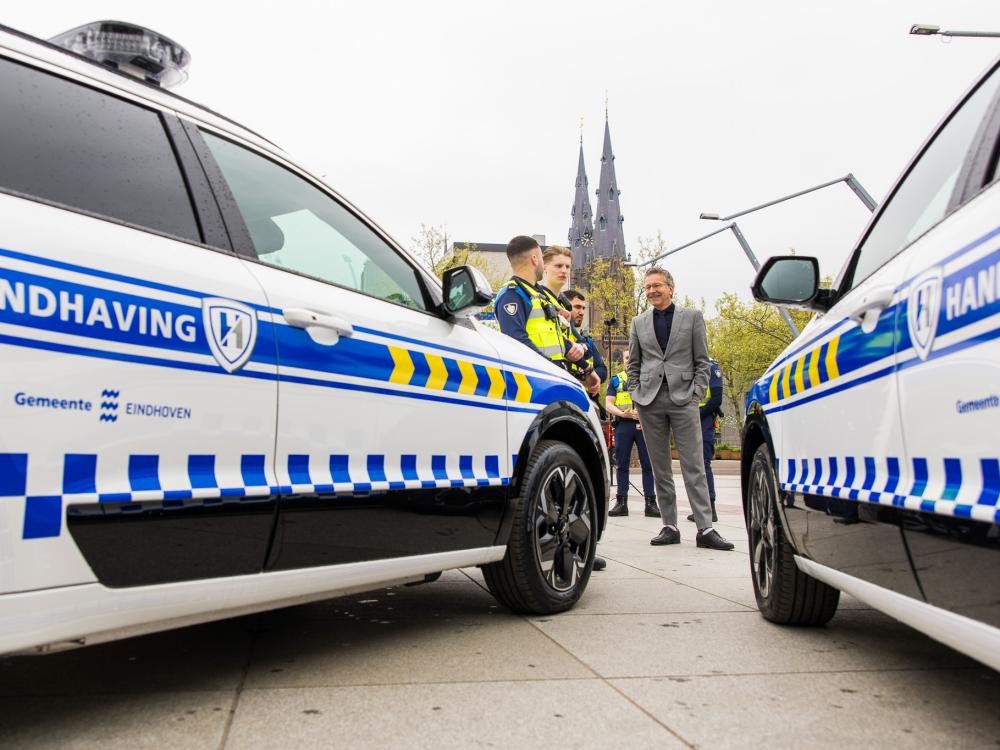Handhavers praten met burgemeester Dijsselbloem naast hun nieuwe dienstauto's