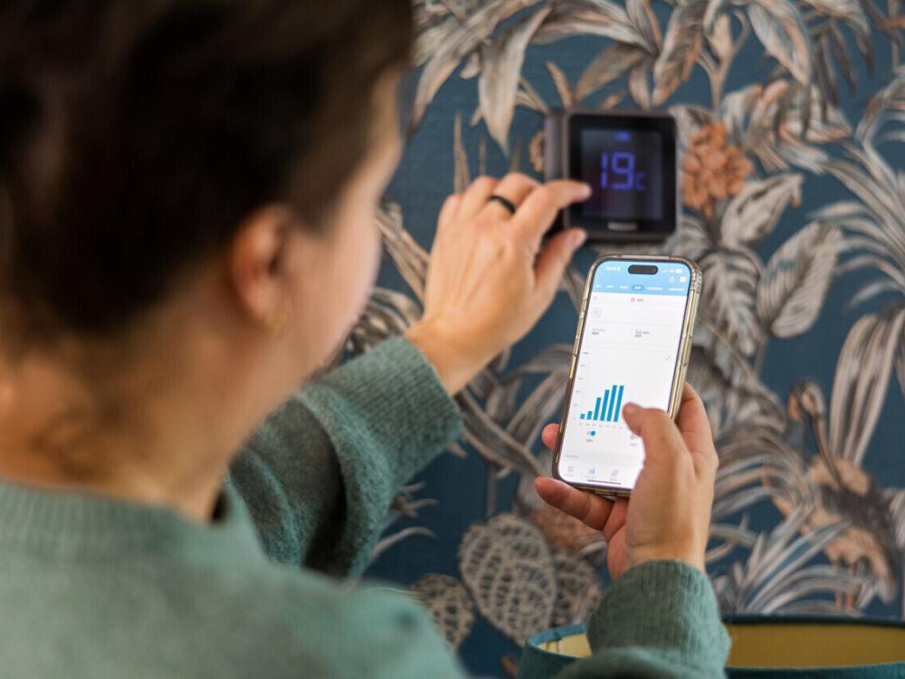 Een vrouw bekijkt haar energieverbruik op haar smartphone